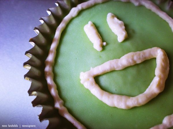 Fotografía de cupcake verde con cara sonriente