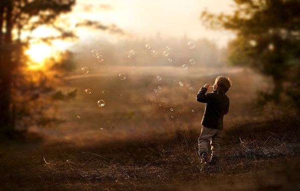 Fotografía de un niño soplando pompas de jabón
